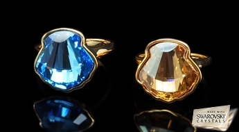 Žilbinoši spožs apzeltīts gredzens „Kristalīna” ar lielu debess krāsas Swarovski™ kristālu.